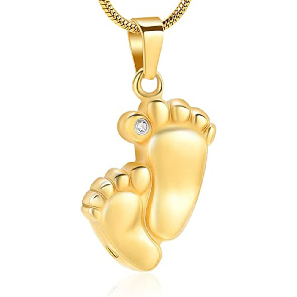Gold baby footprints pendant with a diamond on a white background